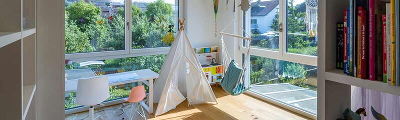 Helle, moderne Kinderzimmeransicht mit Spielzelt, Hängesitz und Blick ins Grüne. | © Name