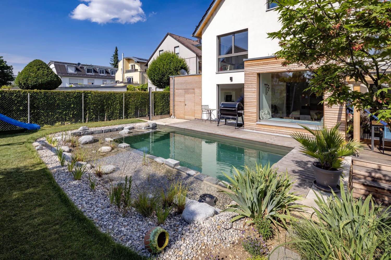 Mehrfamiliehaus, verputztes Holzhaus in München, Schwimmteich,