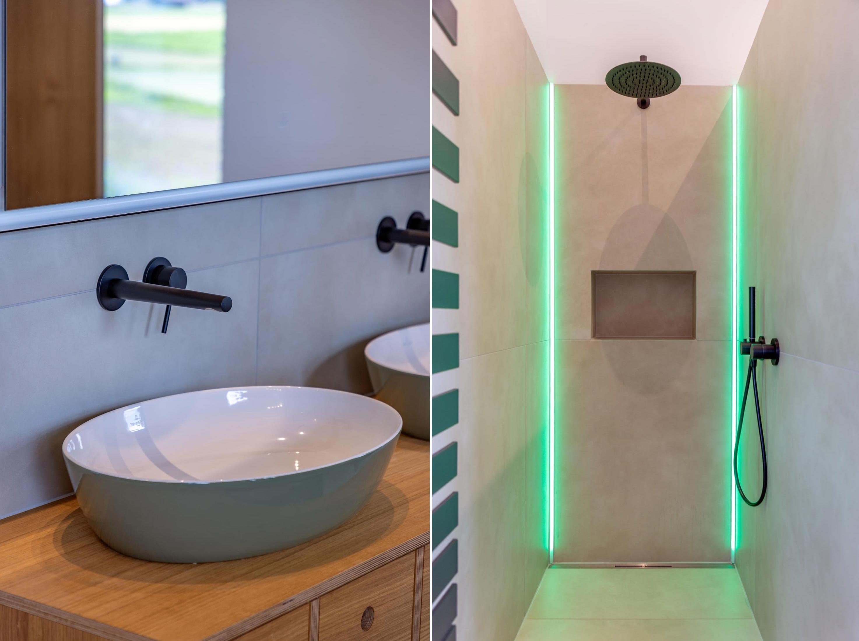 Bad im OG mit Waschbecken und Dusche mit jeweils schwarzen Armaturen