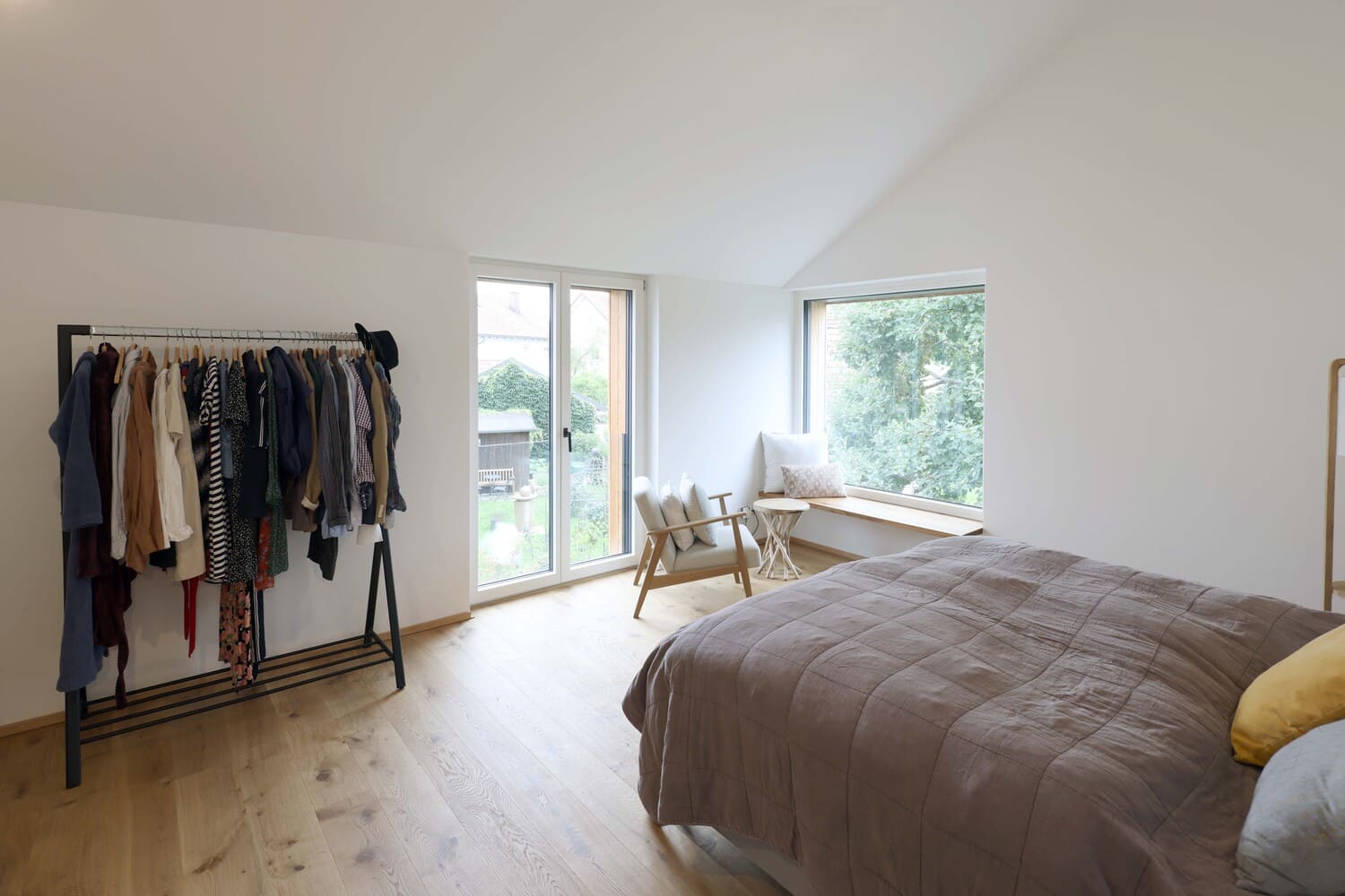 Schlafzimmer mit bodentiefem Fenster und Sitzfenster