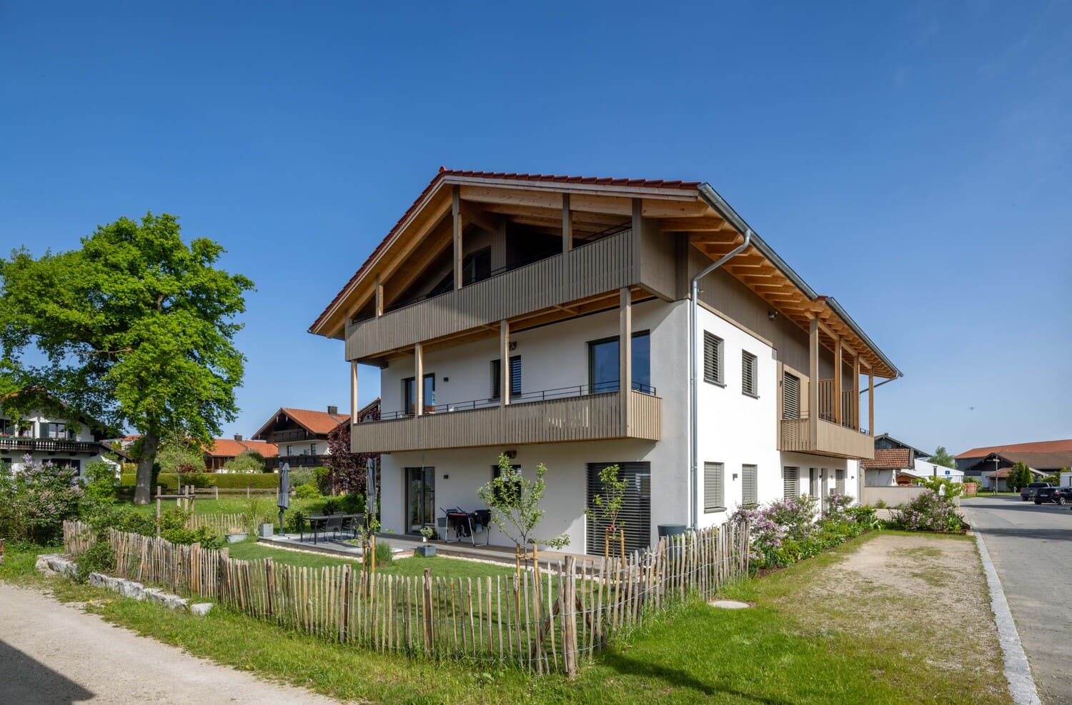 Mehrfamilien Holzhaus in Übersee, Holz- und Putzfassade , drei Stockwerke mit Balkon und Garten